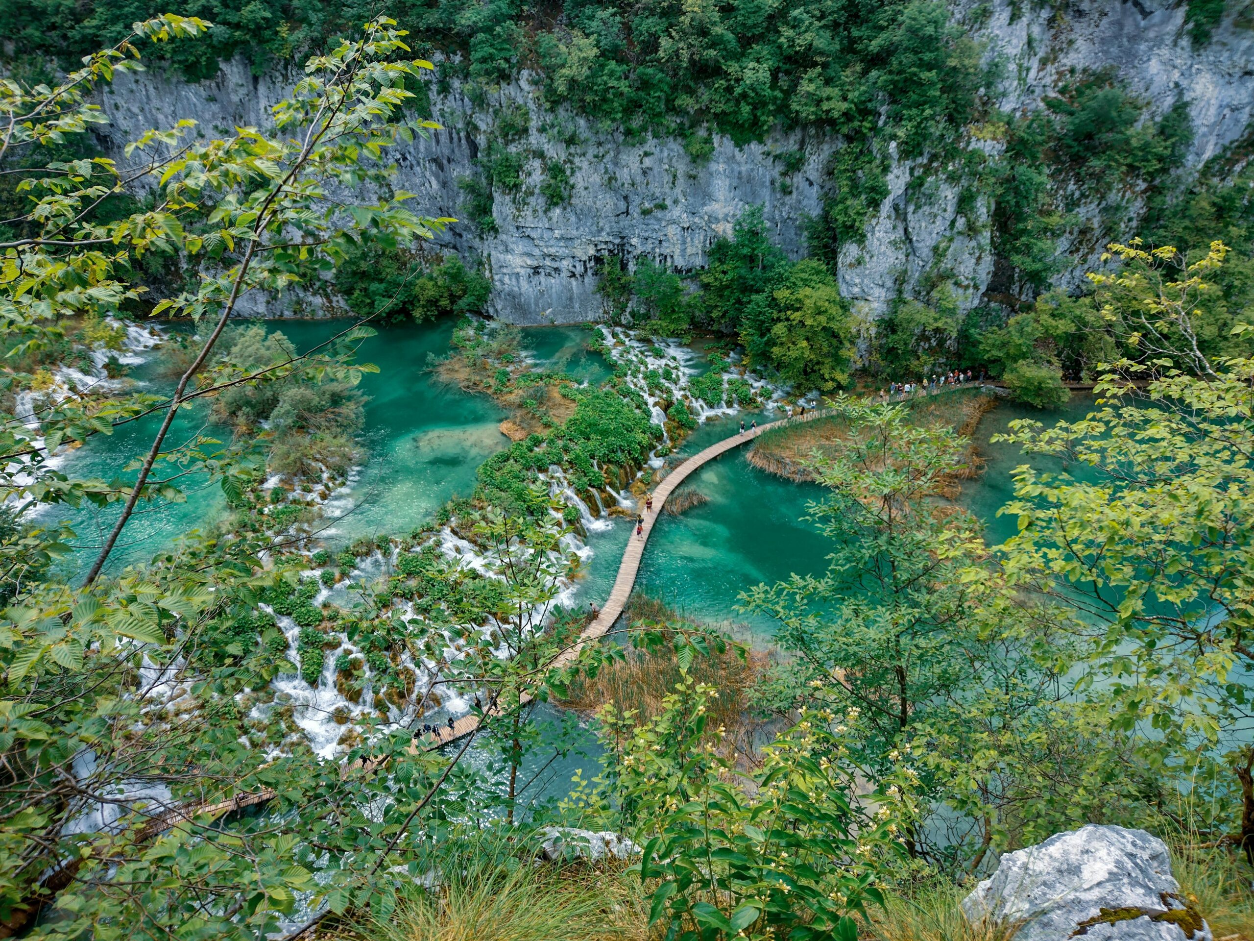 A mesmerizing view of the boardwalk crossing the emerald lakes in Plitvice Lakes National Park, Croatia.