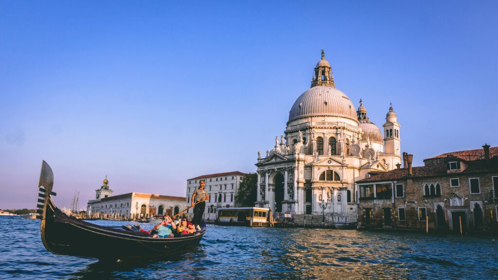 Top 10 Destinations in Italy Scenic view of a gondola ride with Santa Maria della Salute in the background, Venice.