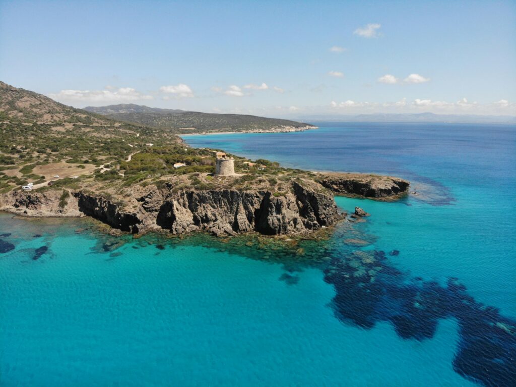 Top 10 Destinations in Italy Stunning coastal view of Torre Cannai and crystal blue waters in Sardinia, Italy.