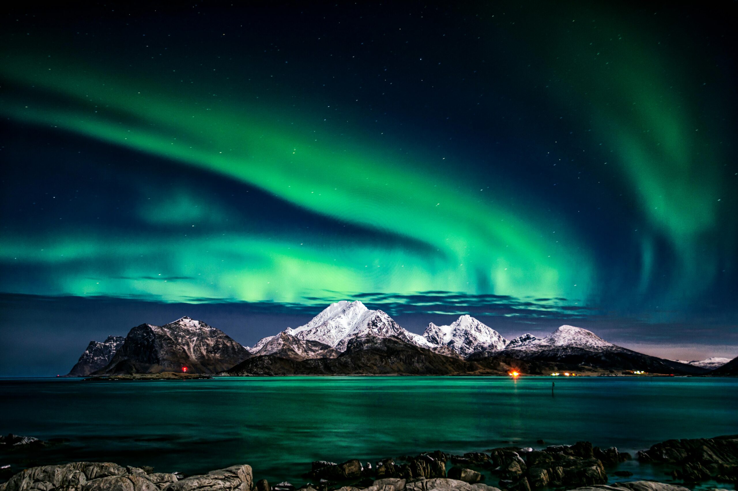 Top 9 Undiscovered Wilderness Retreats You Need to Explore Now Breathtaking view of aurora borealis illuminating the snowy mountains of Lofoten Islands at night.