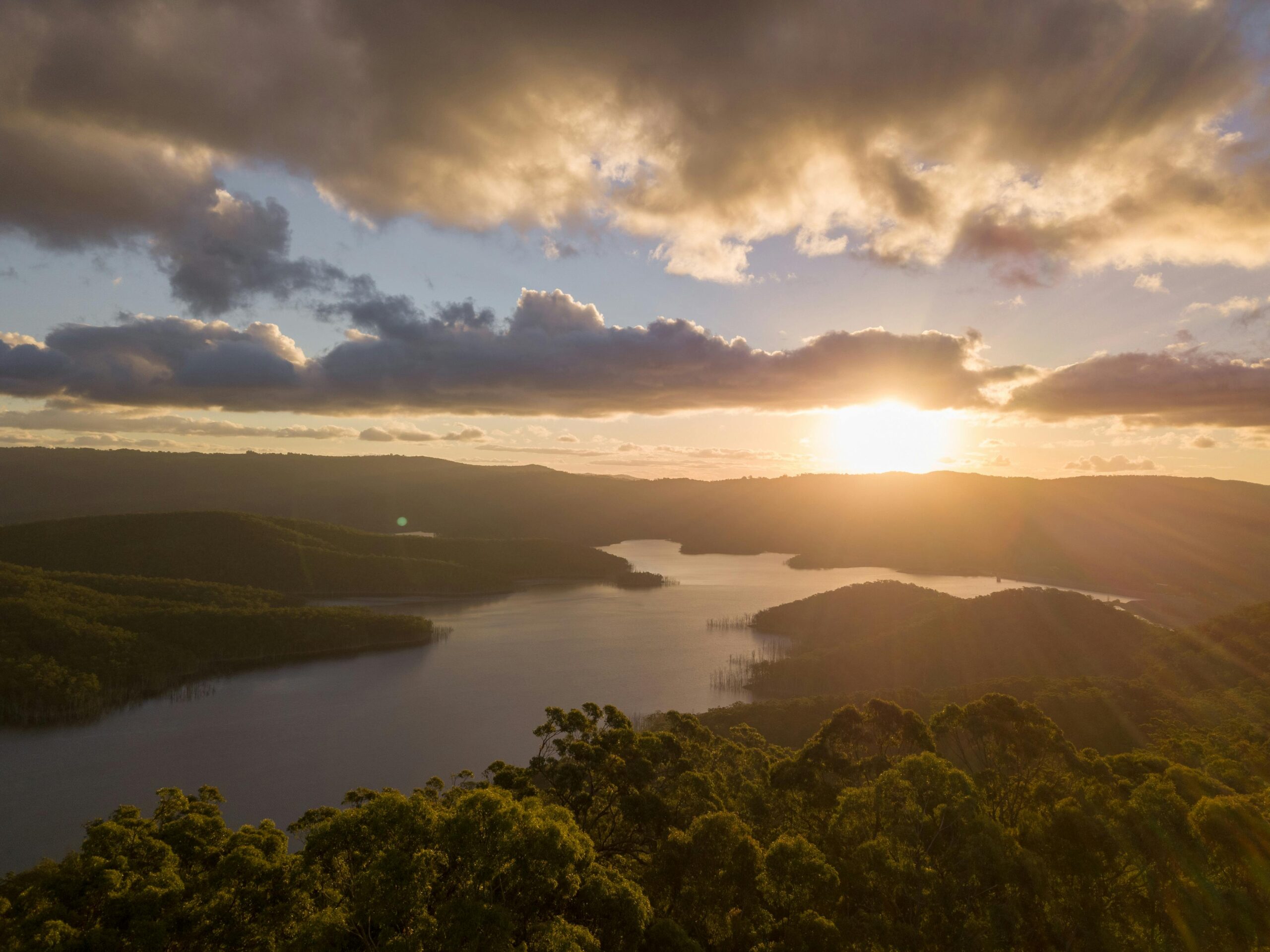 Top 12 Undiscovered River Cruises to Unveil Hidden Worlds A stunning aerial panorama of Hinze Dam at sunset, showcasing serene water reflections and vibrant sky.
