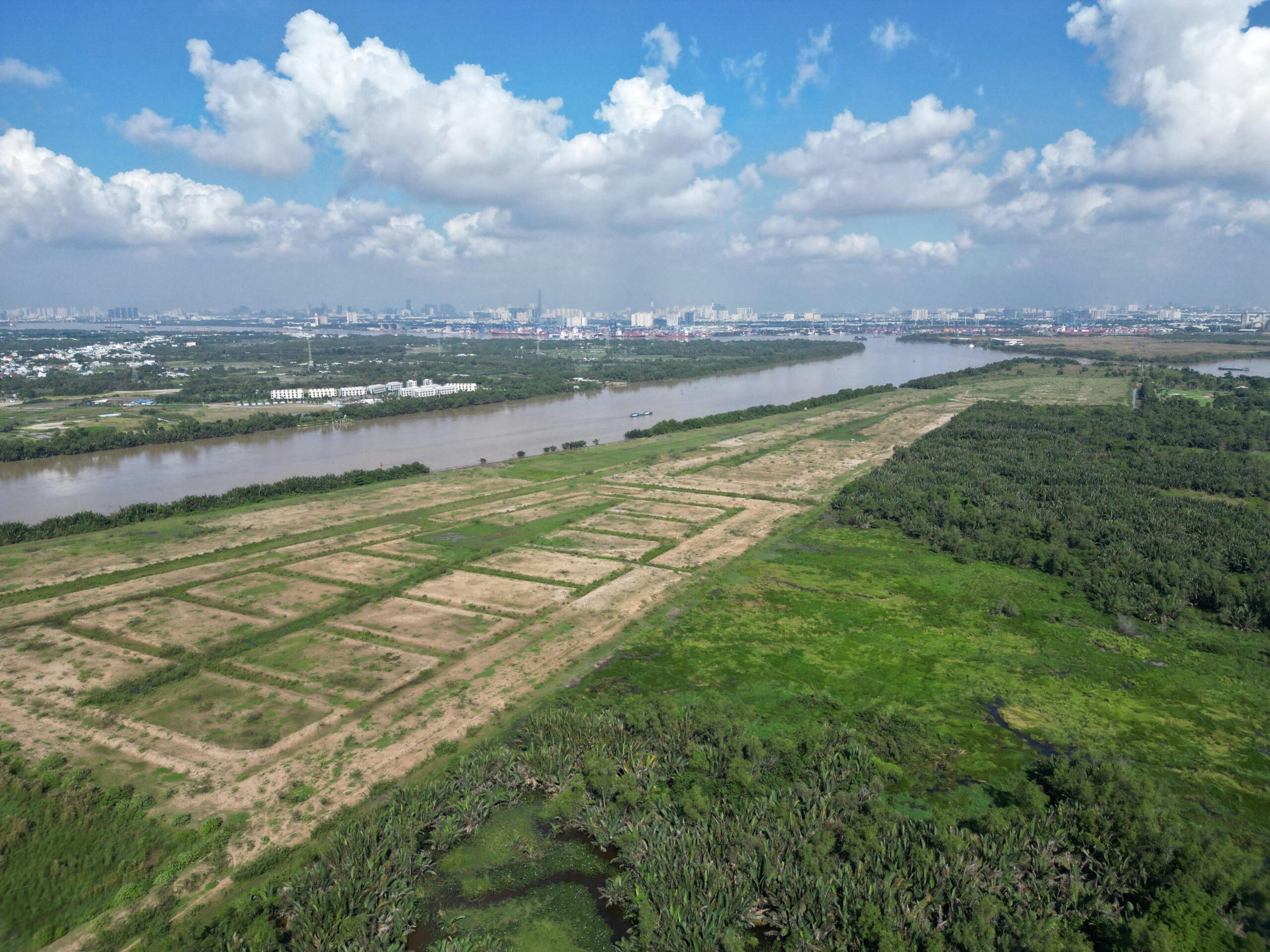 Top 12 Undiscovered River Cruises to Unveil Hidden Worlds Expansive aerial view of a river, greenery, and cityscape in Ho Chi Minh City, Vietnam.