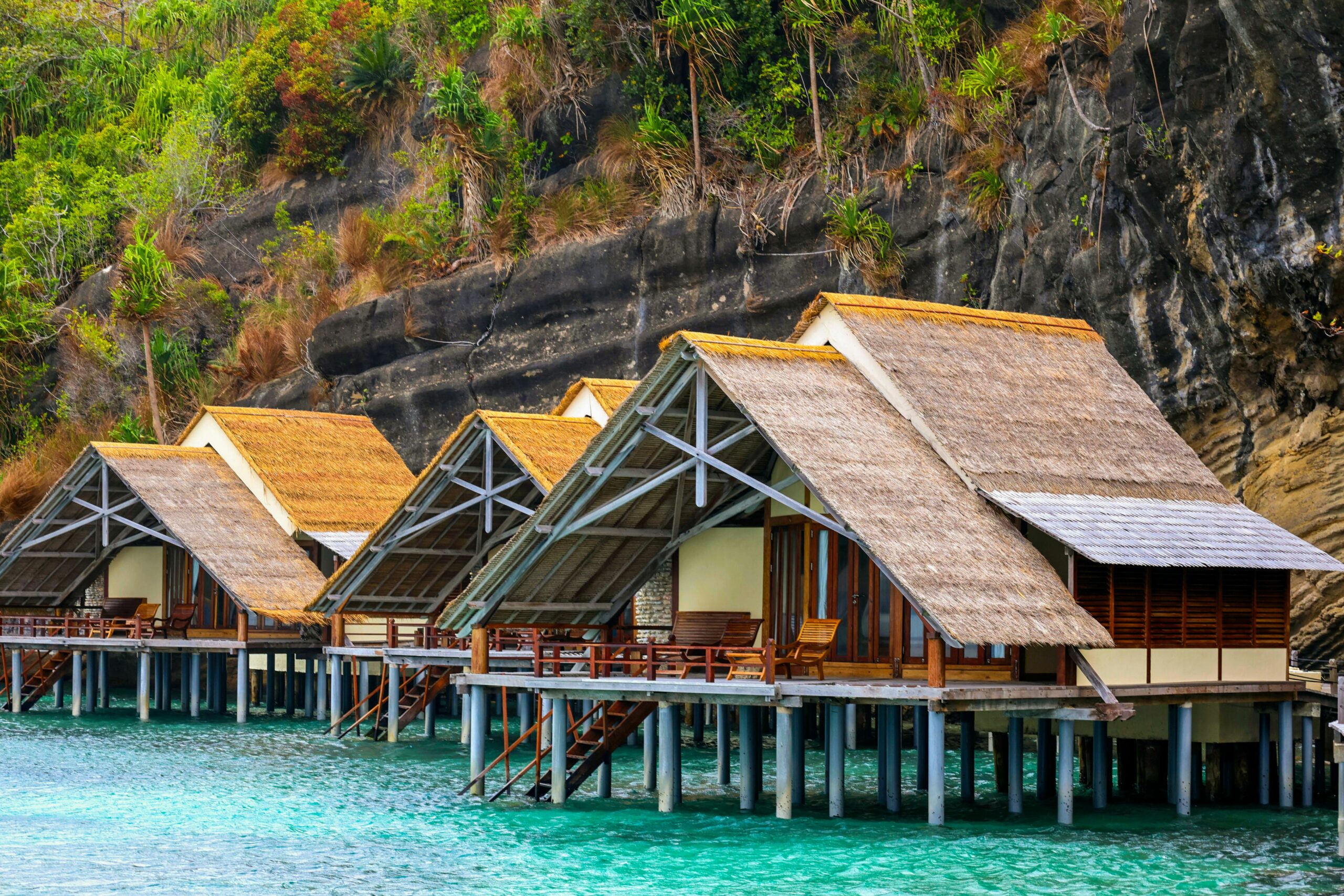 Top 9 Undiscovered Wilderness Retreats You Need to Explore Now Beautiful overwater bungalows in Raja Ampat, Indonesia, surrounded by stunning nature.