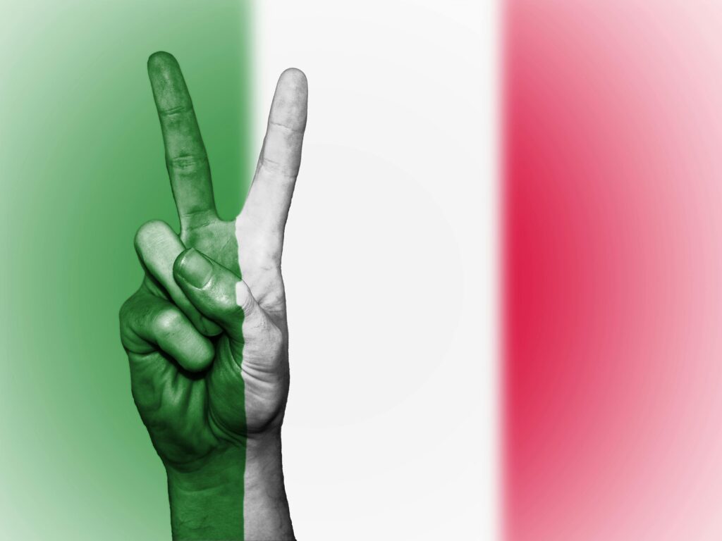 A peace sign gesture overlaid with the Italian flag colors, symbolizing peace and patriotism.