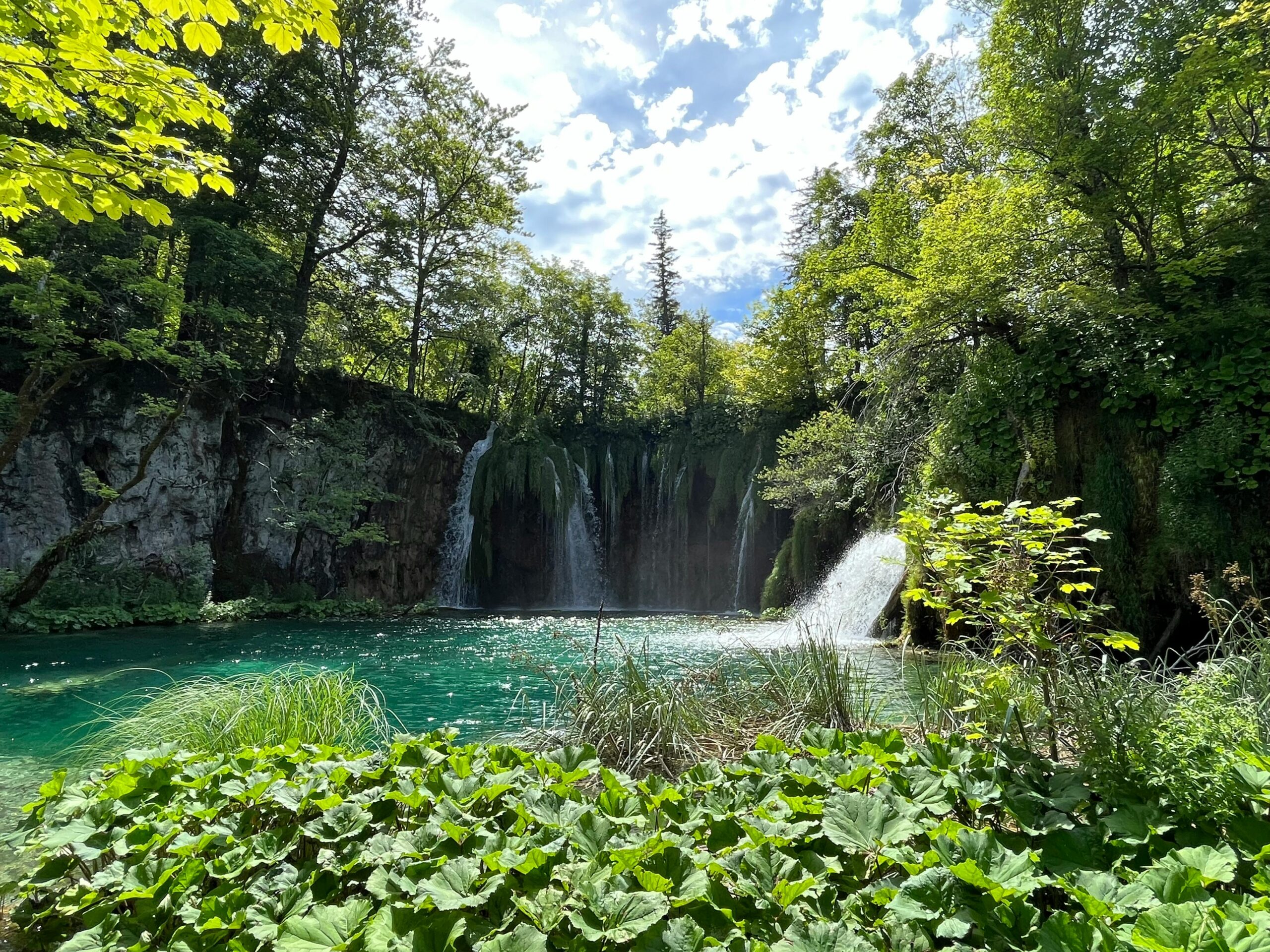 Stunning waterfall surrounded by lush greenery in Plitvice Lakes National Park, Croatia.