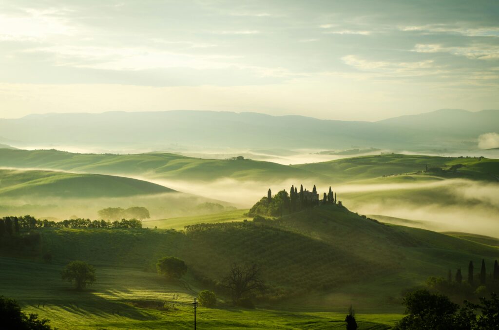 Top 10 Destinations in Italy Breathtaking view of the Tuscany countryside with morning fog and rolling hills.