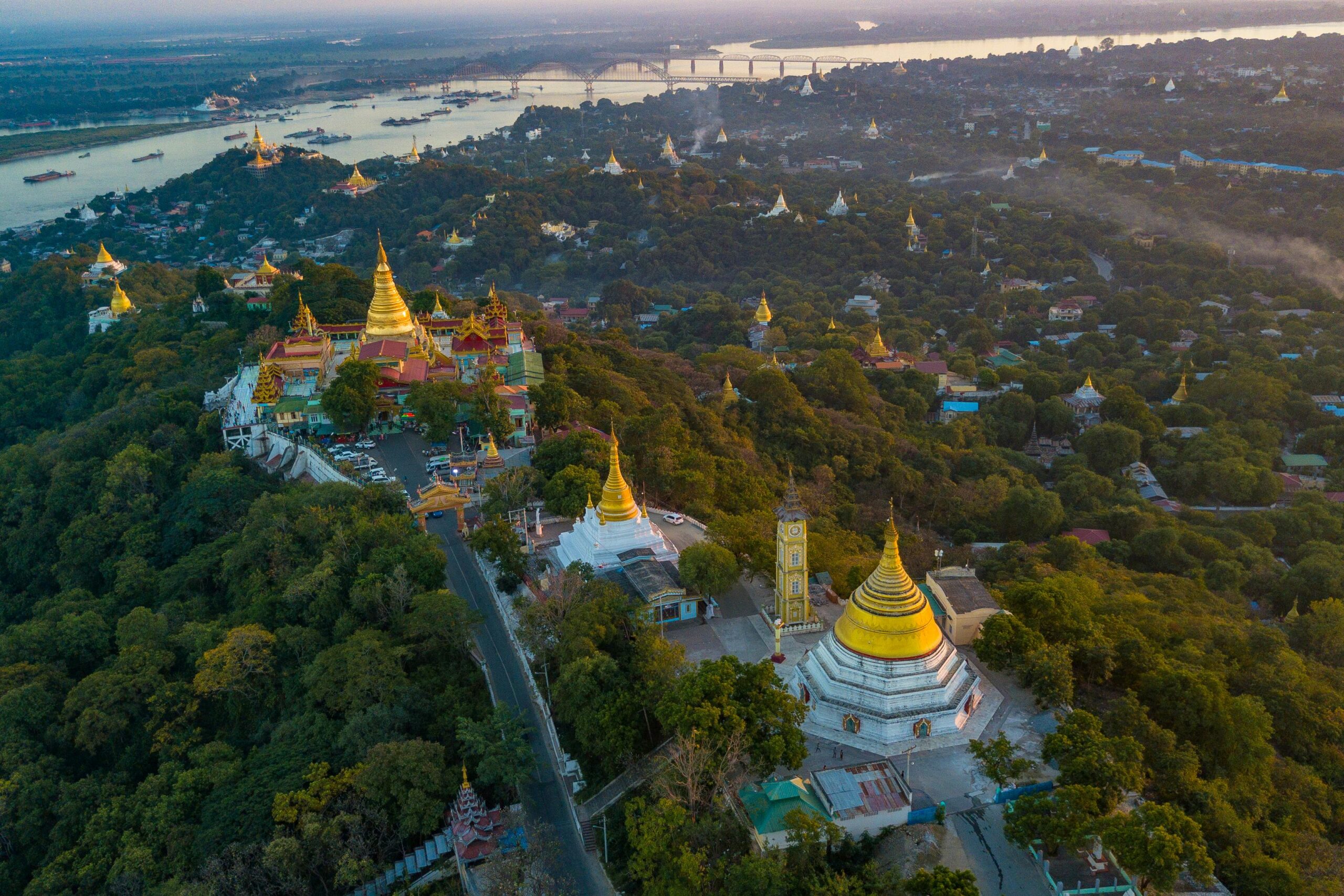 Top 12 Undiscovered River Cruises to Unveil Hidden Worlds Breathtaking aerial view of Mandalay Hill with its golden temples at sunrise, overlooking the Irrawaddy River.