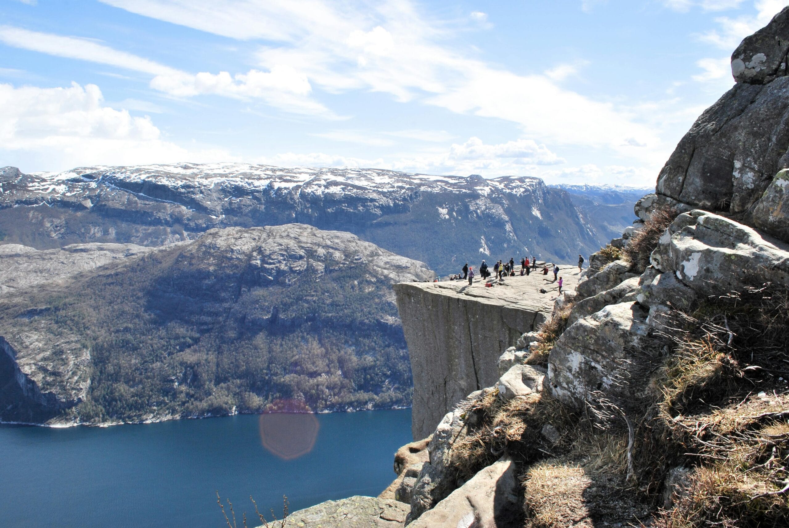 Tourists enjoy the breathtaking view from the famous Preikestolen cliff in Norway.